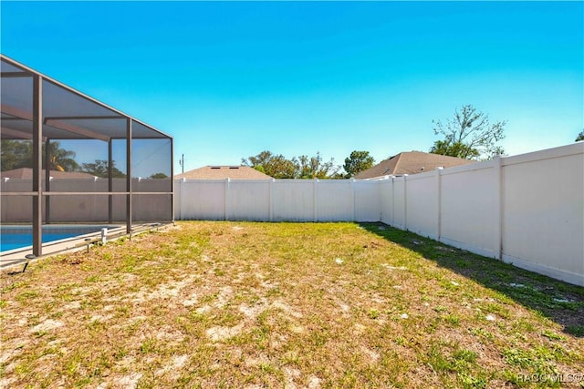 view of yard with a fenced in pool, a lanai, and a fenced backyard