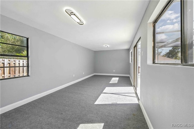 spare room featuring carpet flooring and baseboards