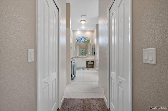 hall with light tile patterned floors