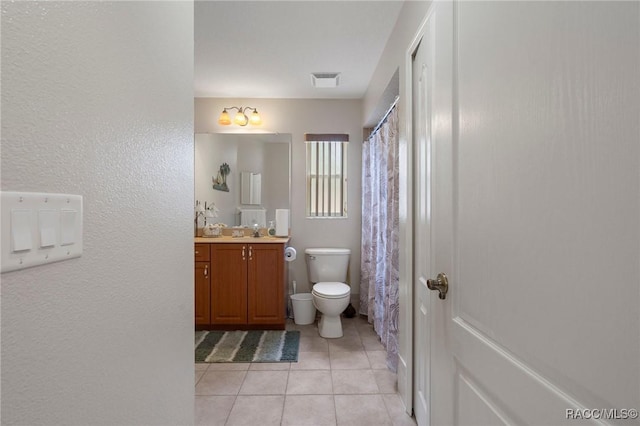 bathroom featuring toilet, vanity, and tile patterned flooring