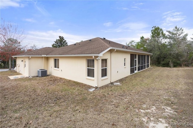 view of side of home featuring a yard, central AC unit, and a sunroom