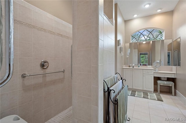 bathroom featuring tile patterned floors, tiled shower, a high ceiling, and vanity