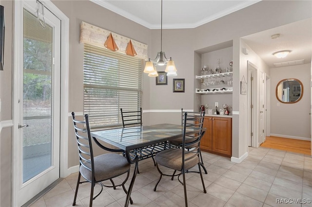 tiled dining room with an inviting chandelier, ornamental molding, and built in features