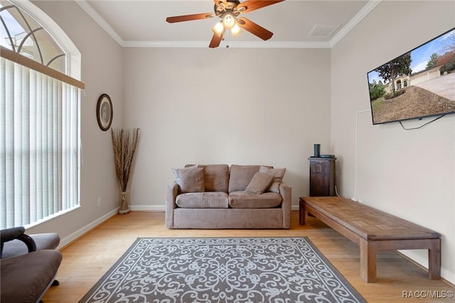 living room featuring ceiling fan, ornamental molding, and light hardwood / wood-style flooring