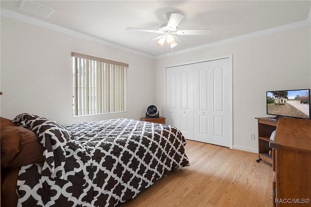 bedroom with ceiling fan, ornamental molding, a closet, and light hardwood / wood-style flooring