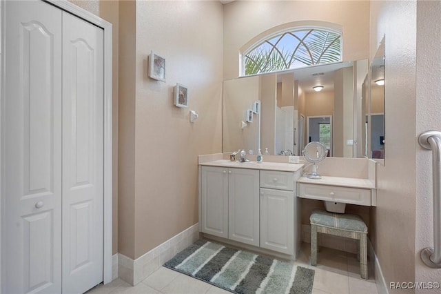 bathroom with tile patterned floors, a towering ceiling, and vanity