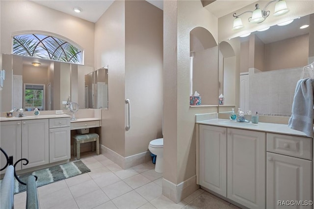 bathroom featuring a high ceiling, a wealth of natural light, vanity, and tile patterned flooring