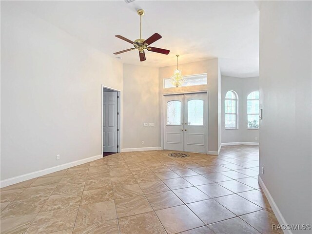 foyer featuring light tile patterned floors, ceiling fan, and french doors