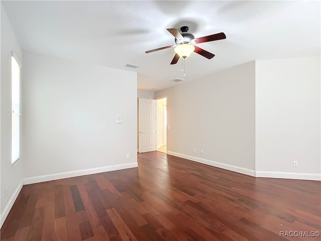 empty room with dark hardwood / wood-style flooring and ceiling fan