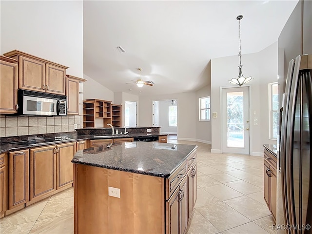 kitchen with lofted ceiling, ceiling fan, decorative backsplash, a kitchen island, and stainless steel appliances