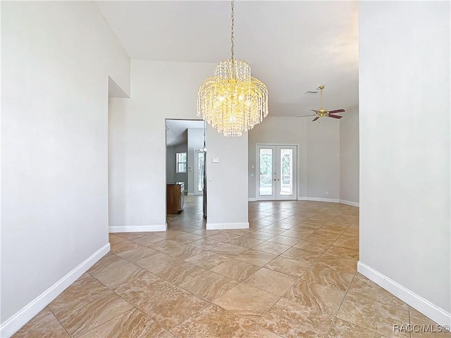 spare room featuring baseboards, french doors, and ceiling fan with notable chandelier