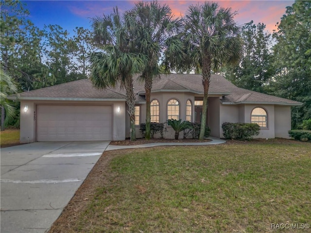 view of front of house featuring a garage and a lawn