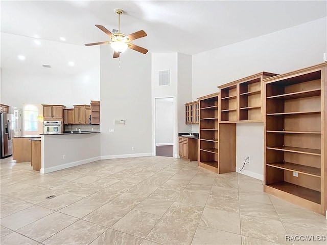 unfurnished living room with baseboards, high vaulted ceiling, visible vents, and a ceiling fan