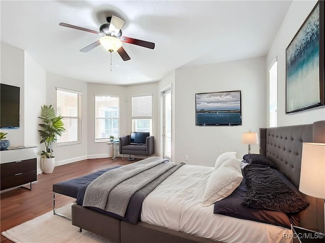 bedroom featuring baseboards, wood finished floors, and a ceiling fan