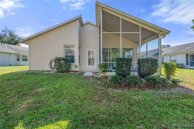 rear view of property featuring a lawn