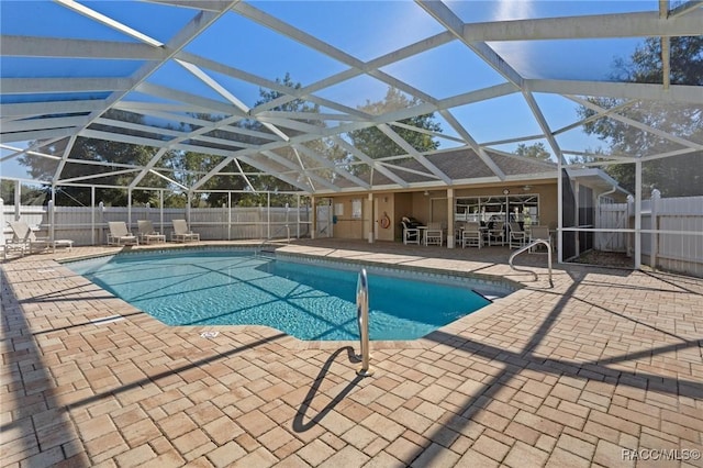 view of swimming pool with glass enclosure and a patio area