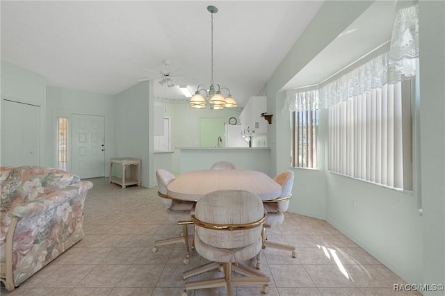 dining space with light tile patterned floors, vaulted ceiling, and a chandelier