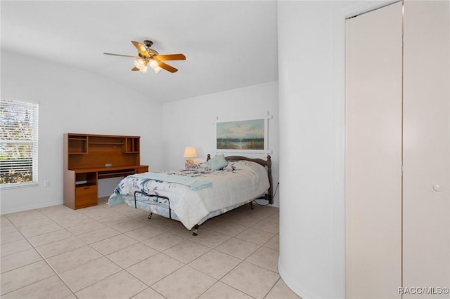 bedroom featuring vaulted ceiling, ceiling fan, light tile patterned floors, and a closet