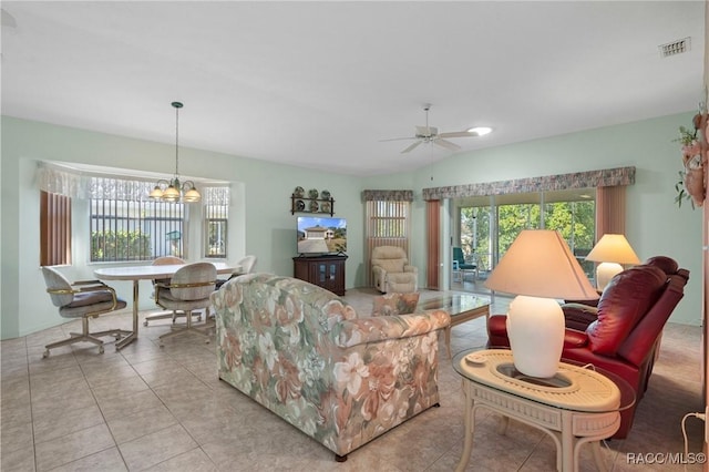 living room with lofted ceiling, light tile patterned floors, and ceiling fan with notable chandelier