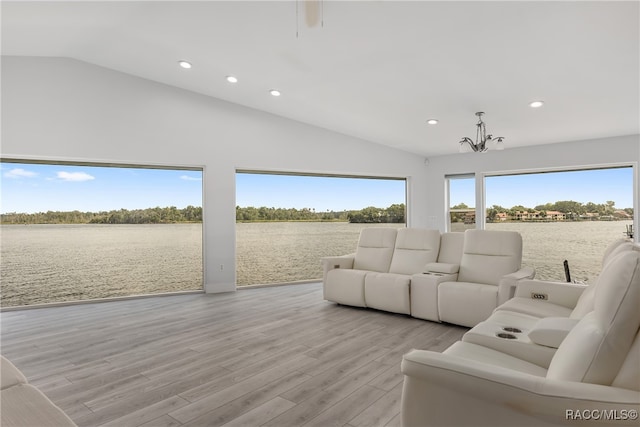 living room with a water view, light wood-type flooring, and a chandelier