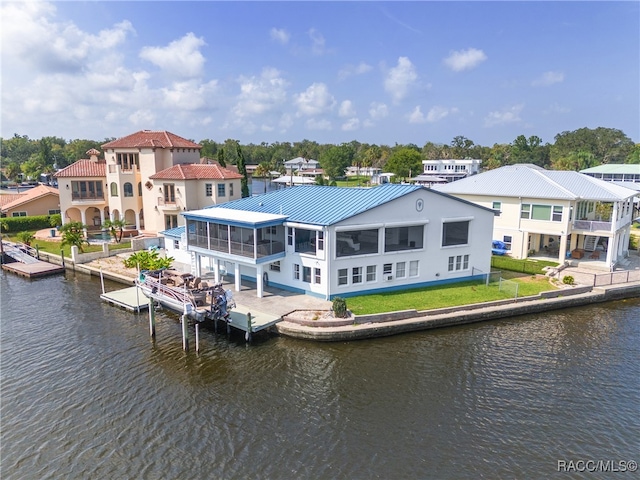 rear view of property with a water view and a sunroom