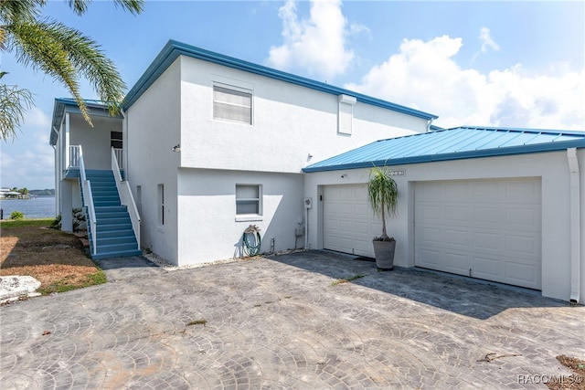 rear view of house featuring a water view and a garage