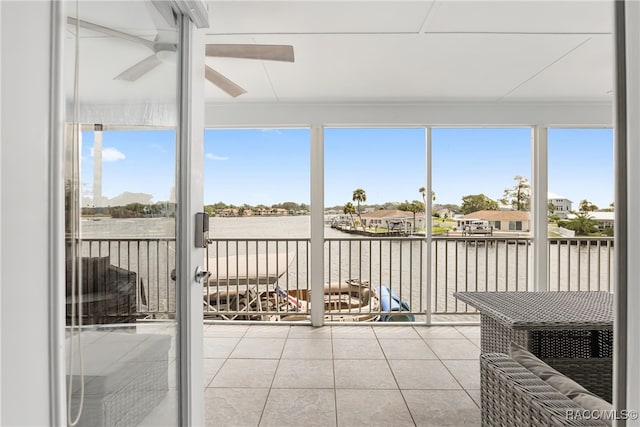 sunroom with ceiling fan, a water view, and a wealth of natural light