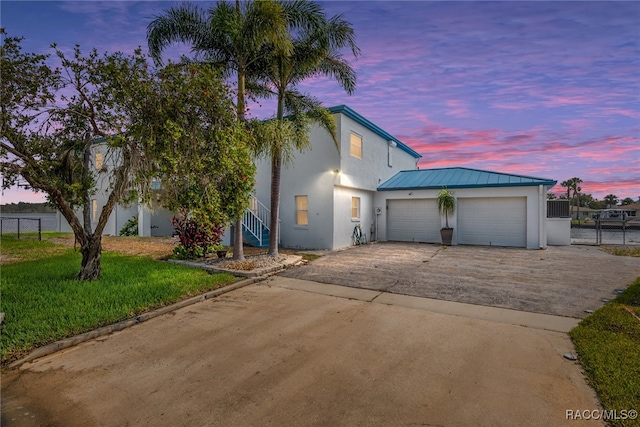 view of front of house with a garage and a yard