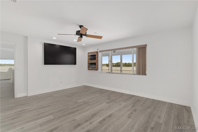 empty room with ceiling fan and light hardwood / wood-style flooring