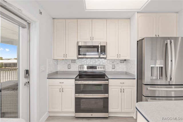 kitchen with light hardwood / wood-style floors, stainless steel appliances, and tasteful backsplash