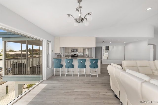 living room with a notable chandelier and light hardwood / wood-style floors