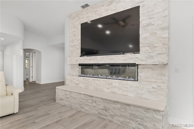 interior details with hardwood / wood-style floors and a stone fireplace