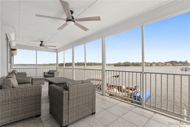 sunroom with a water view and ceiling fan