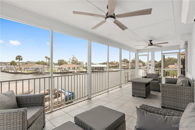 sunroom with a water view, ceiling fan, and a healthy amount of sunlight