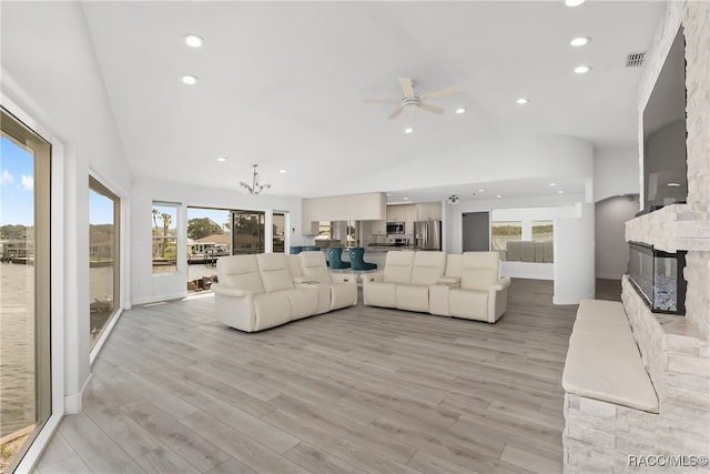 living room featuring a fireplace, a wealth of natural light, light hardwood / wood-style flooring, and lofted ceiling