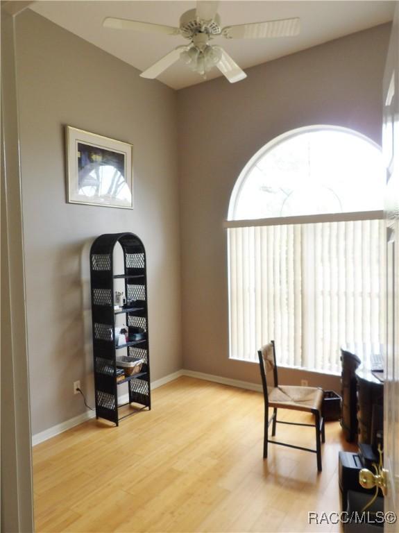 office space with light wood-style flooring, baseboards, and ceiling fan