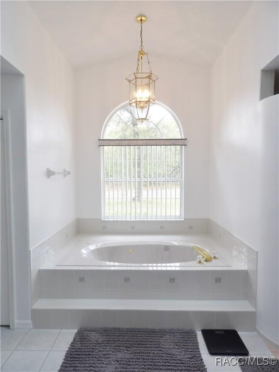 bathroom featuring a bath, plenty of natural light, and tile patterned floors