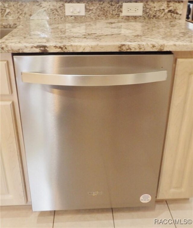 room details featuring dishwasher and light stone counters