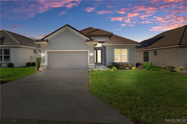 view of front facade with a lawn and a garage