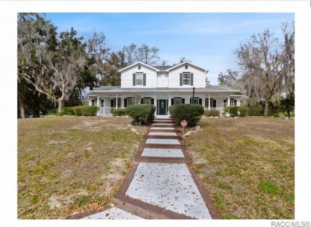 farmhouse inspired home with a porch and a front yard