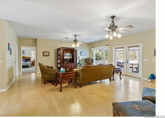 living room with ceiling fan, light hardwood / wood-style floors, and french doors