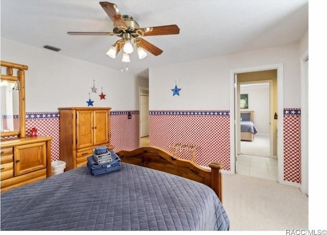 carpeted bedroom featuring tile walls and ceiling fan