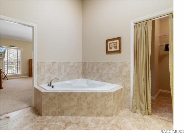 bathroom with tiled tub and tile patterned floors