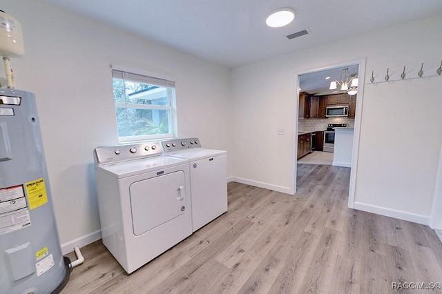 washroom with washer and dryer, light hardwood / wood-style floors, and water heater