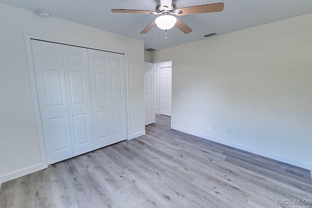 unfurnished bedroom featuring ceiling fan, light hardwood / wood-style floors, and a closet