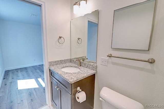 bathroom featuring vanity, hardwood / wood-style flooring, and toilet