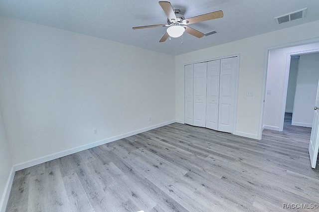 unfurnished bedroom featuring light hardwood / wood-style floors, a closet, and ceiling fan