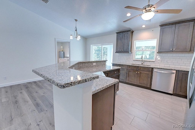 kitchen featuring a kitchen island, decorative light fixtures, tasteful backsplash, sink, and stainless steel dishwasher