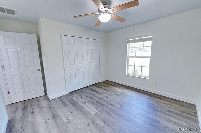 unfurnished bedroom featuring a closet, ceiling fan, and light wood-type flooring