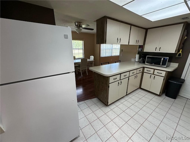 2510 W Dolphin Dr, Citrus Springs, FL 34434 - kitchen with freestanding refrigerator, stainless steel microwave, light countertops, ceiling fan, and a peninsula